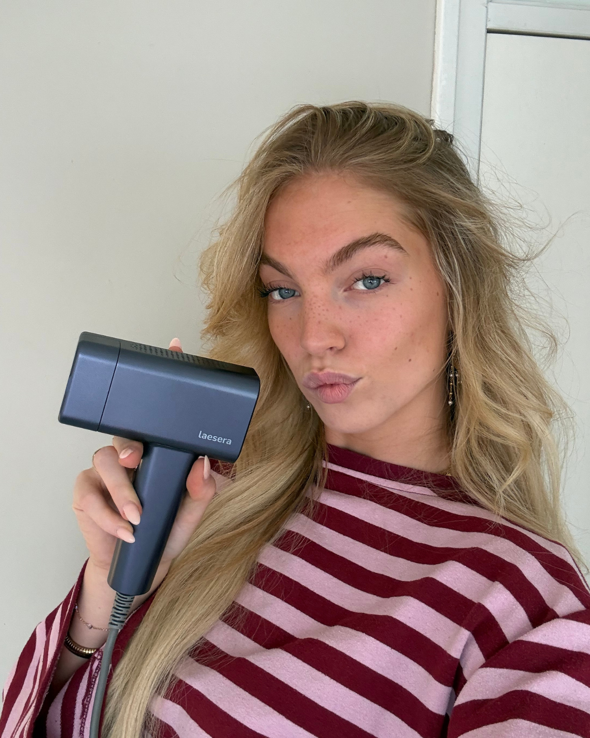 Vrouw houdt de Laesera Nova One IPL vast tijdens gebruik
