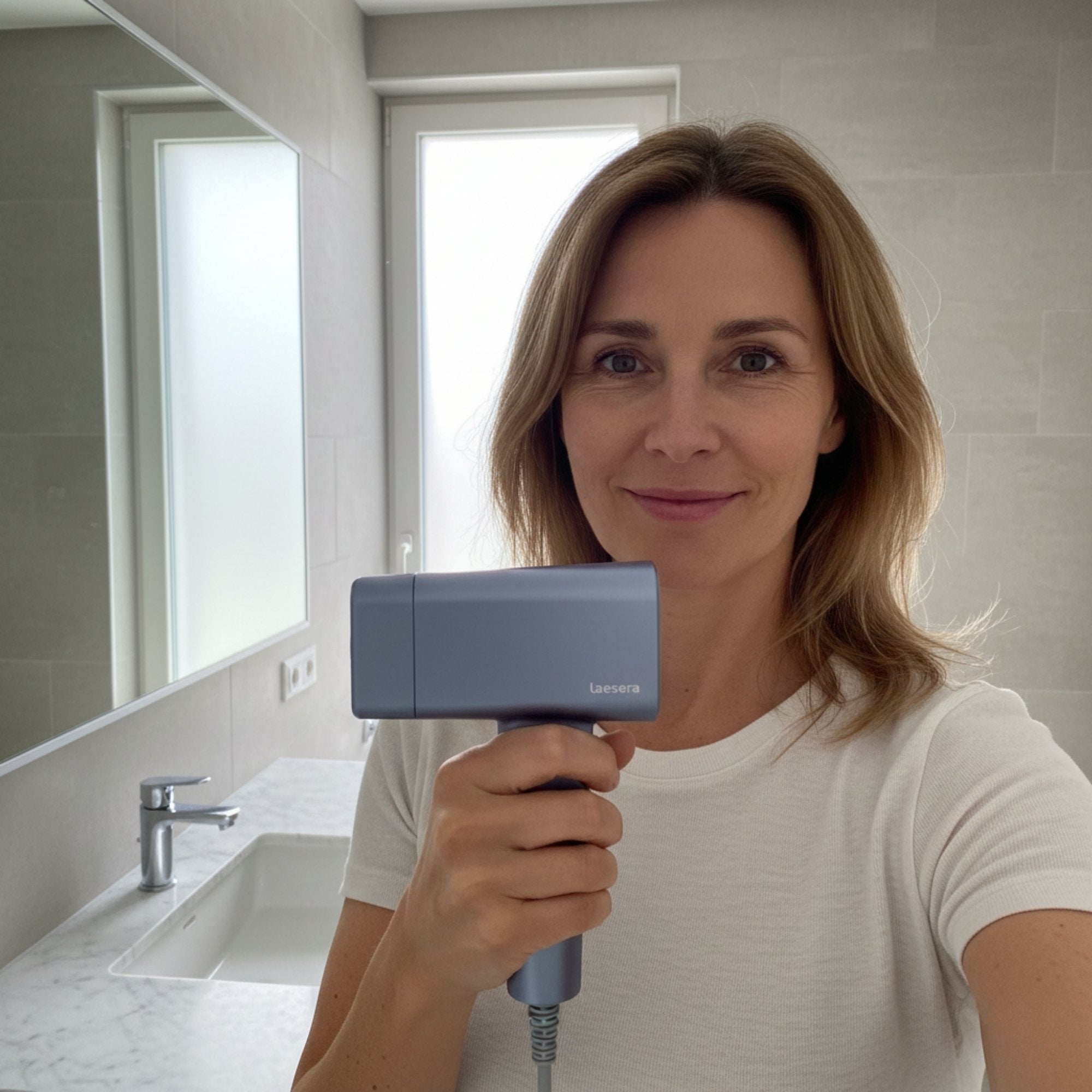 Vrouw gebruikt het Nova One IPL laserontharing apparaat van Laesera thuis in badkamer